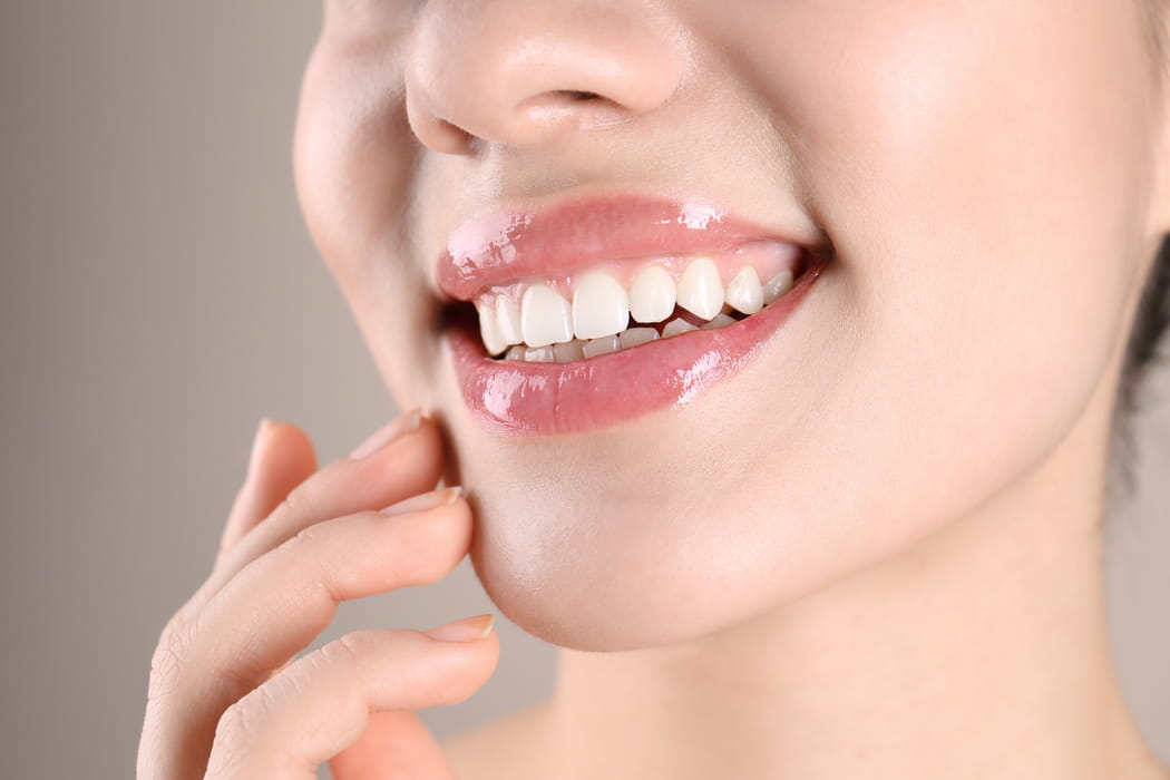 Zbliżenie zdrowego, białego uśmiechu po leczeniu z zakresu periodontologii